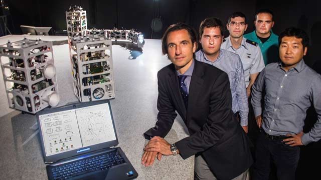 Prof. Marcello Romano and the NPS Spacecraft Robotics Lab research team with the POSEIDYN test bed and floating spacecraft simulators. 